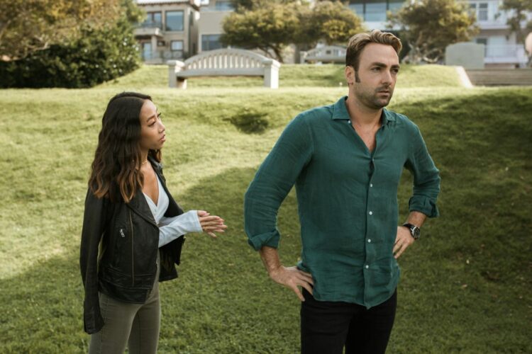 An interracial couple having an intense conversation outdoors, highlighting relationship conflict.
