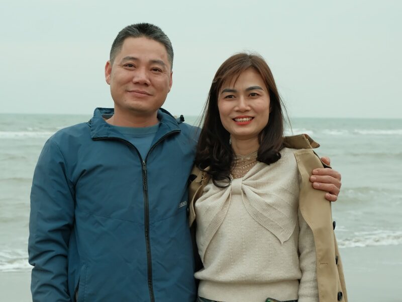 a man standing next to a woman on a beach