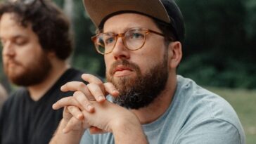 a man sitting at a picnic table with a plate of food