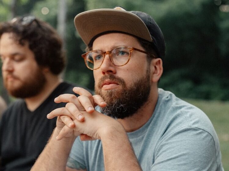 a man sitting at a picnic table with a plate of food