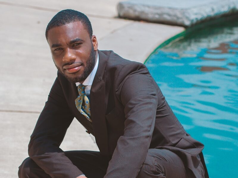 man in black 2-piece suit near swimming pool