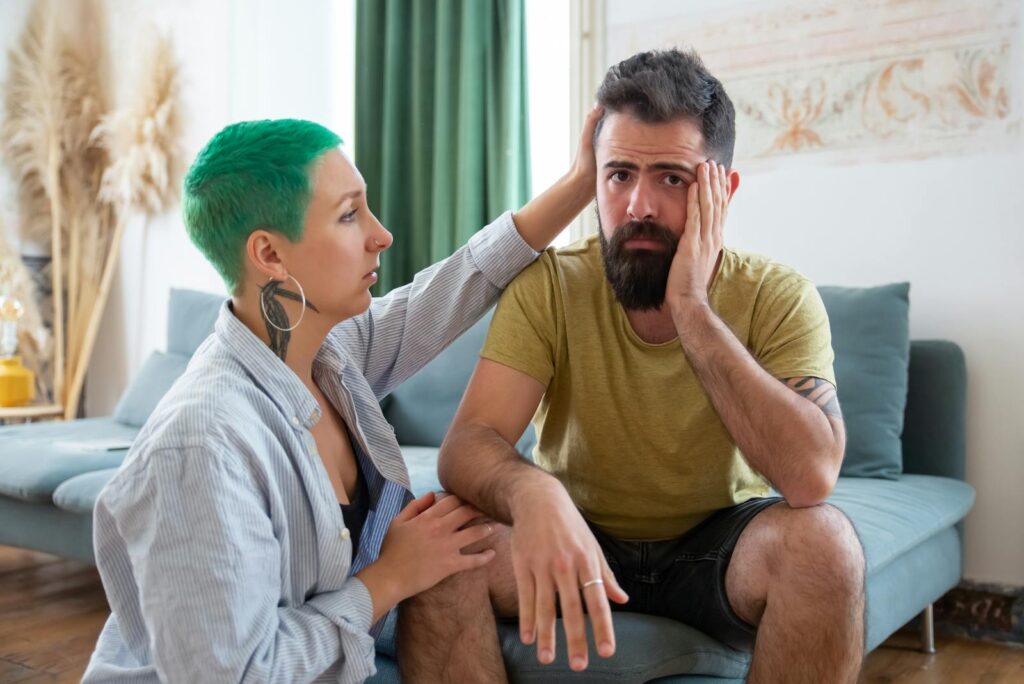 A couple shares an emotional exchange at home, offering comfort and support.