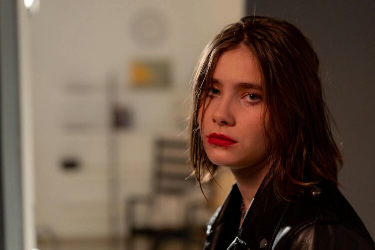 Emotional portrait of a young woman with red lips in an indoor setting.