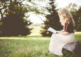 woman sitting while reading book