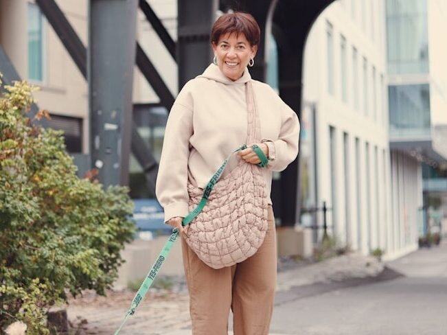A woman walking a small dog on a leash