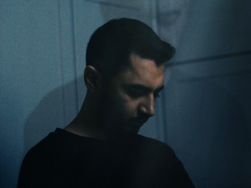 a man standing in front of a wall with a shadow on it