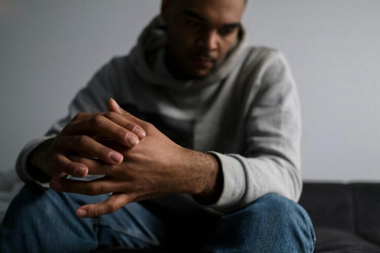 A young man sitting in solitude, expressing deep thoughts and emotions.