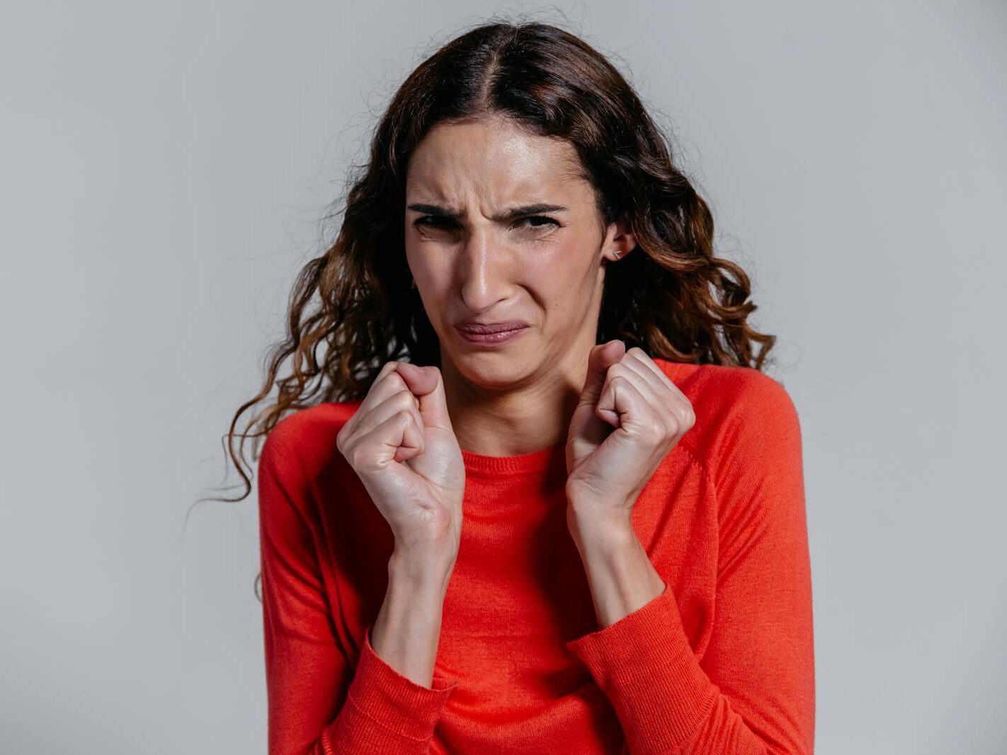 A woman displaying a disgusted facial expression indoors.