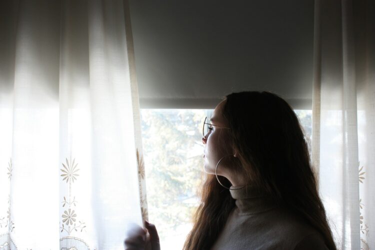 woman standing near window inside room