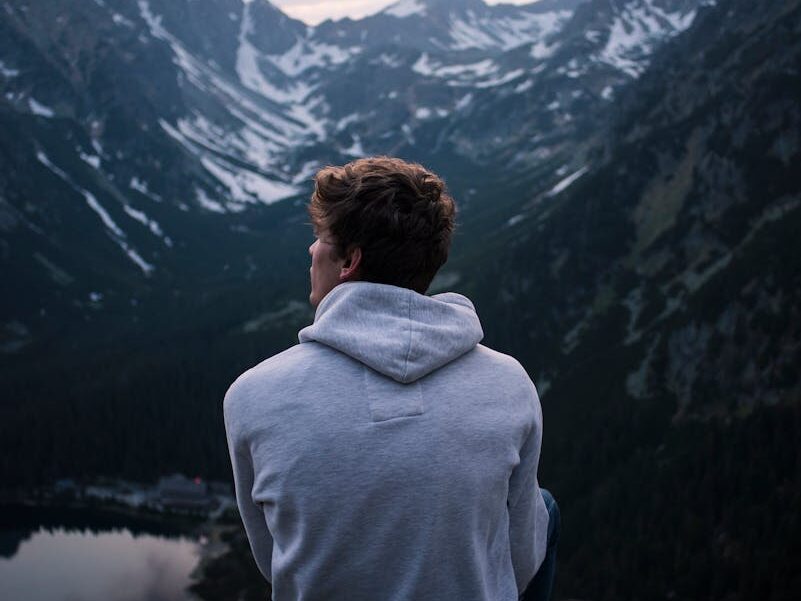 A person enjoying a serene mountain view at twilight, embracing solitude and adventure.