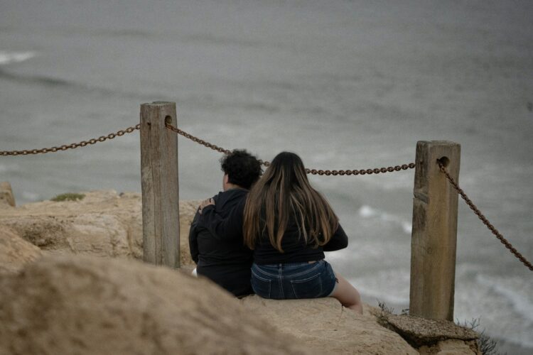 A couple sits and observes the ocean.