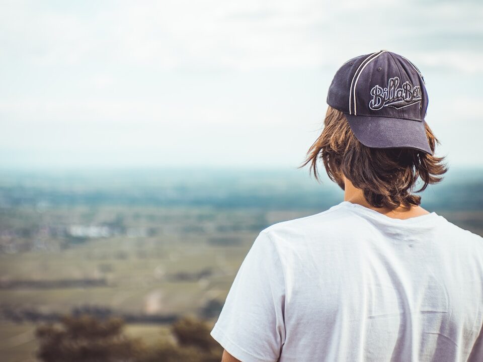 man in white crew neck t-shirt wearing black cap