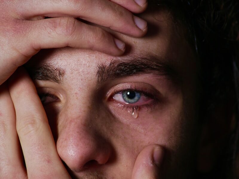 a man holding his hands to his face