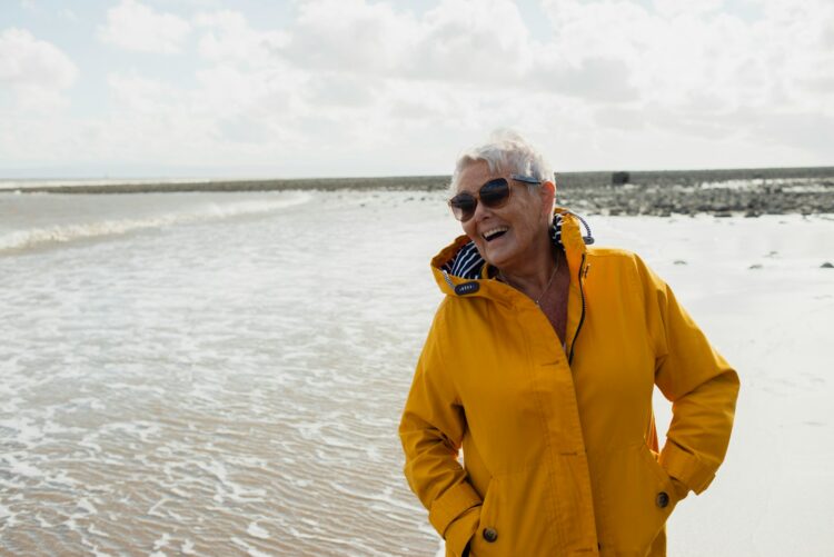 a woman standing on a beach next to the ocean