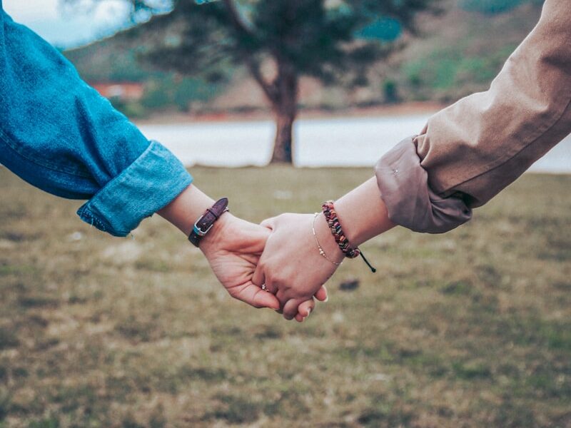 two persons holding hands