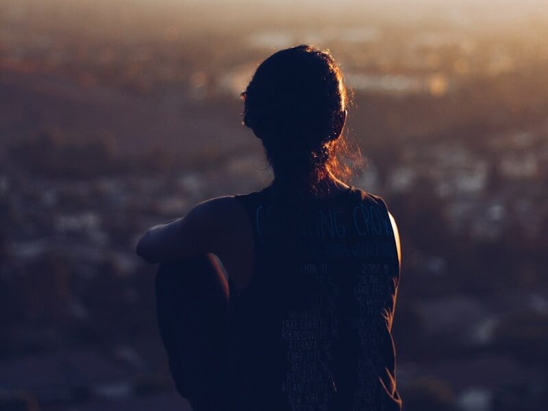woman sitting on brown rock during daytime