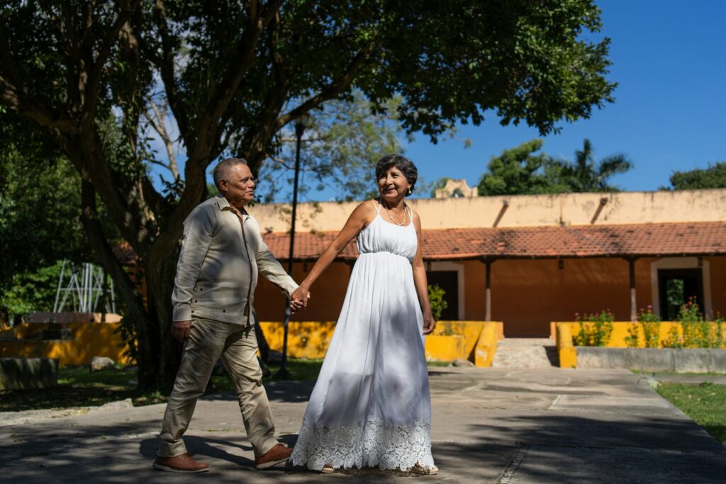 A couple holds hands while walking happily.