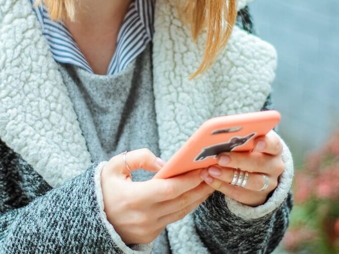 woman smiling while using her phone