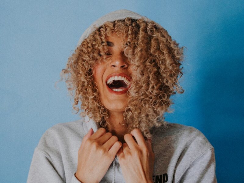 smiling woman wearing gray hoodie