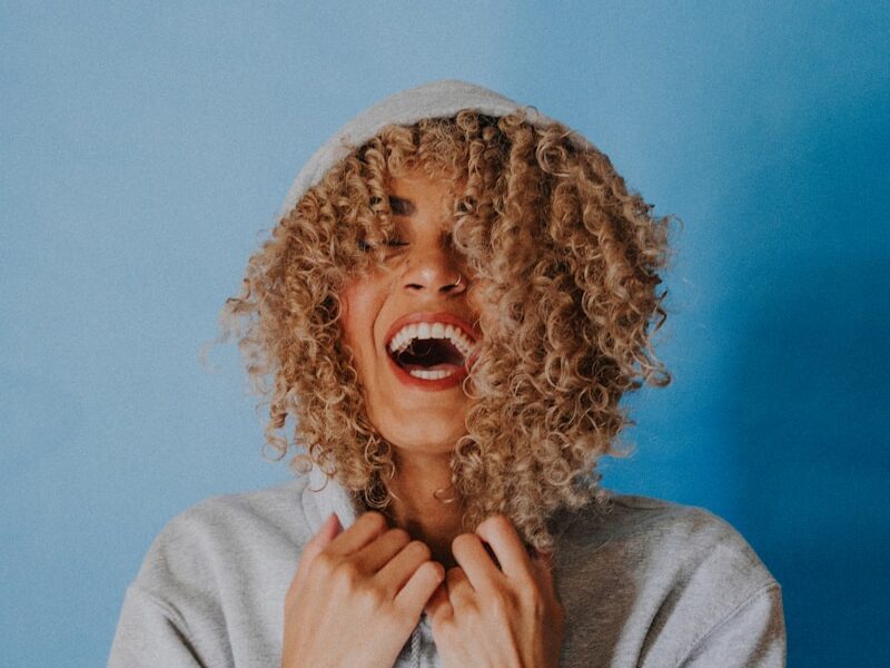 smiling woman wearing gray hoodie
