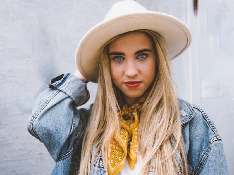 woman wearing blue denim jacket and white hat