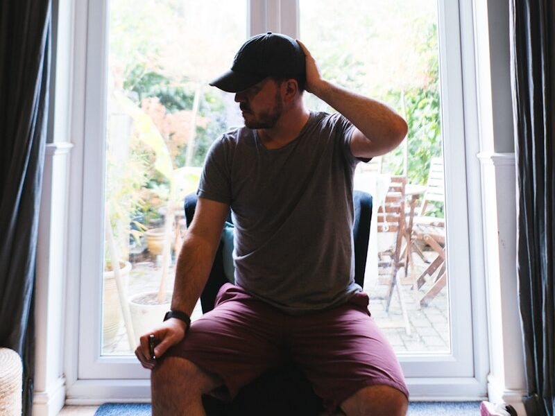 A man sitting on the floor in front of a window