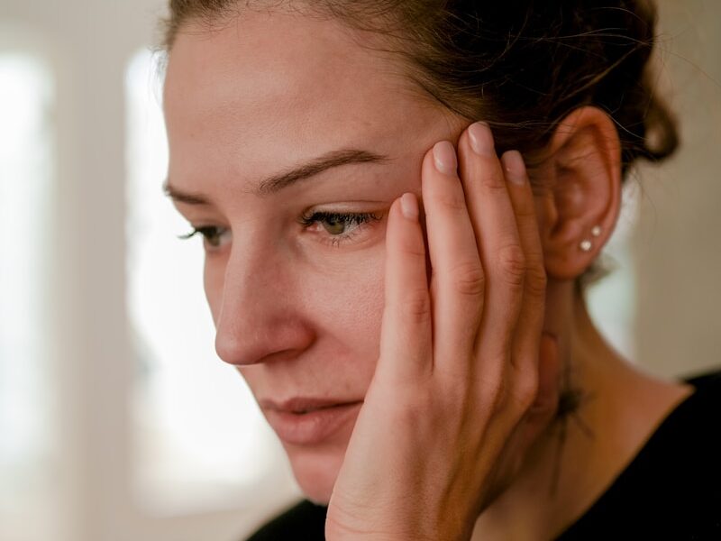 a person with the hand on the face
