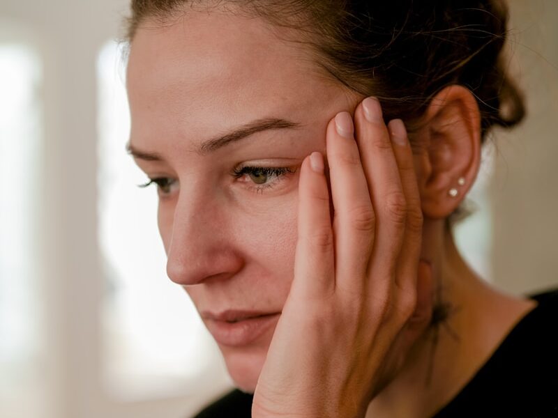 a person with the hand on the face