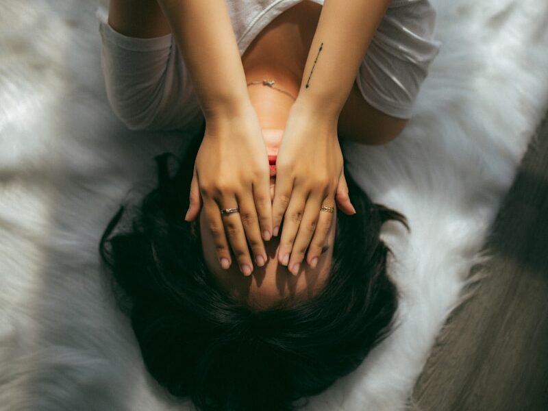 a woman holds her hands over her face