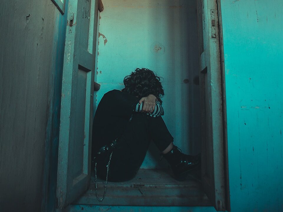 man in black jacket sitting on doorway