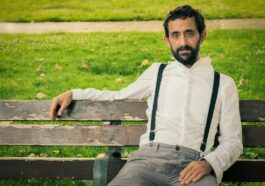 man wearing white dress shirt sitting on outdoor bench