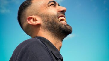 smiling man wearing black collared top