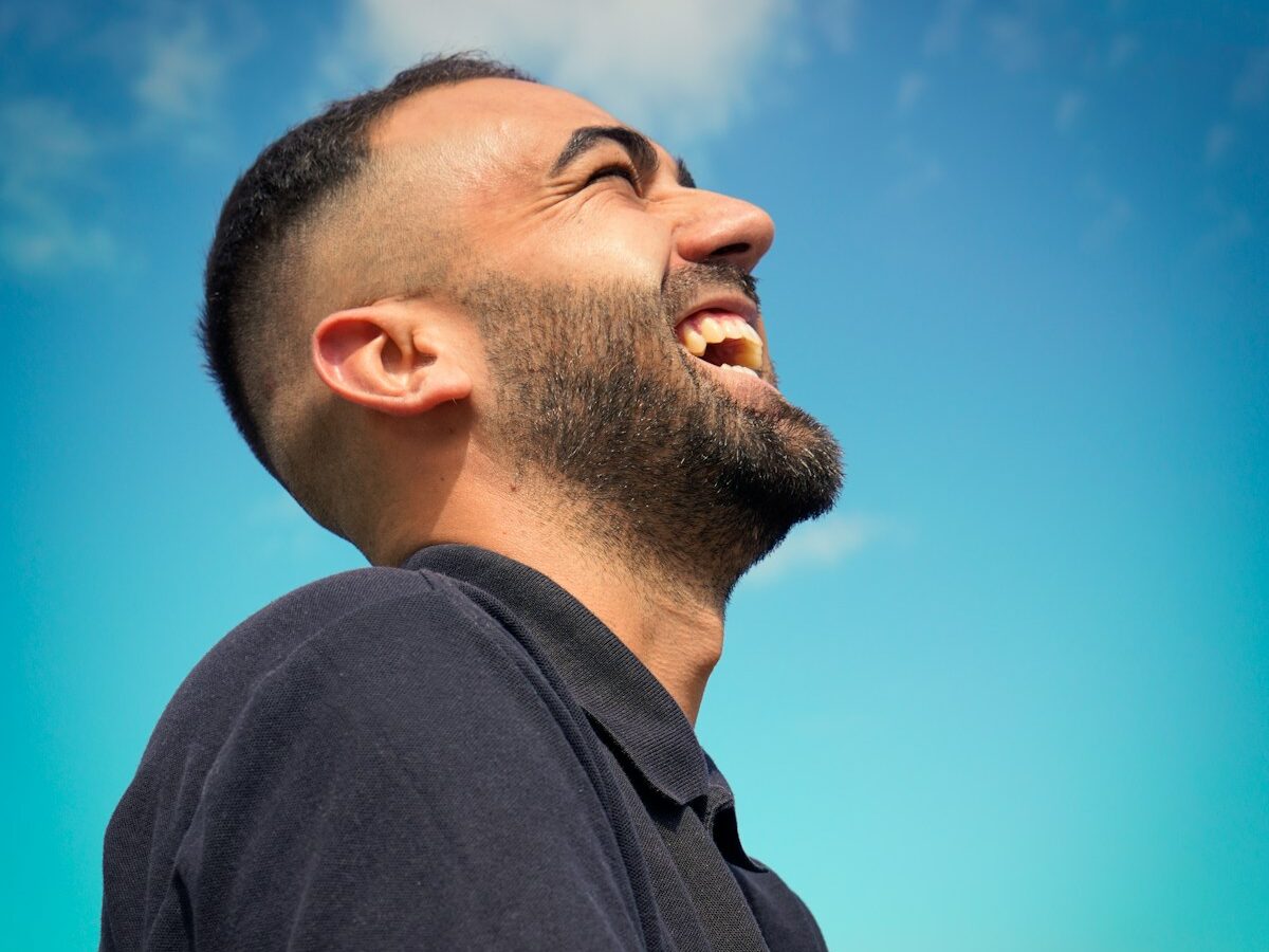 smiling man wearing black collared top