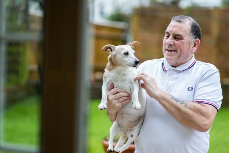 a man holding a small dog in his hands