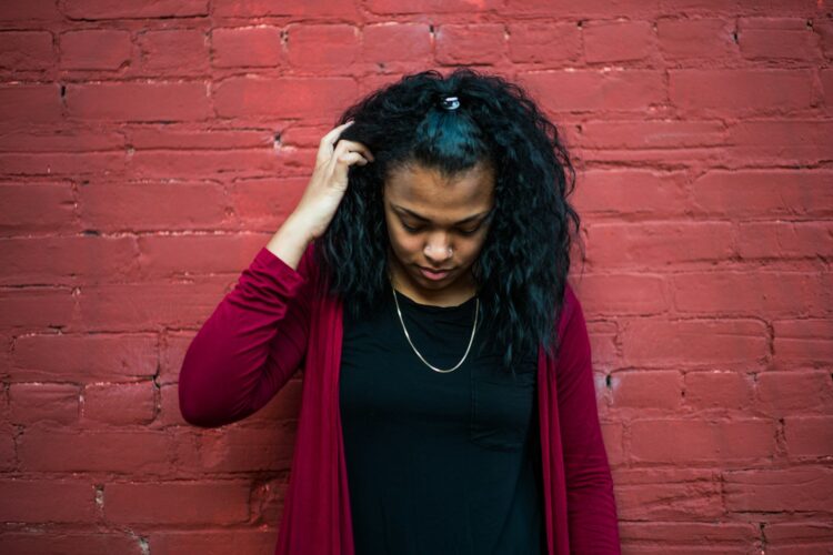 woman standing behind red wall