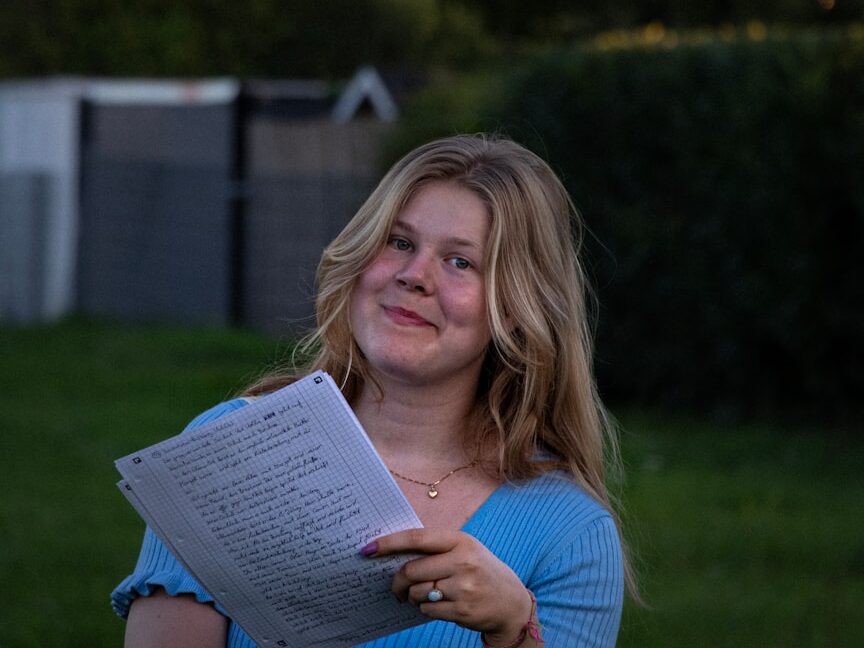 a woman in a blue shirt is holding a book