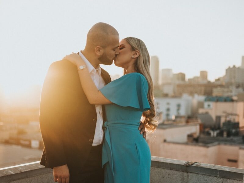 woman in blue sleeveless dress standing beside man in black suit