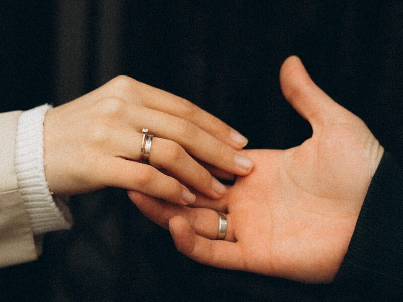 a pair of hands holding a ring