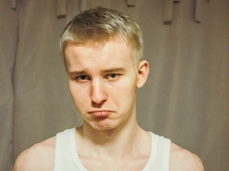 a man in a tank top is making a face