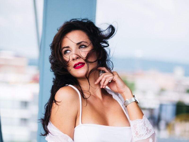 woman in white off shoulder dress sitting on yellow chair