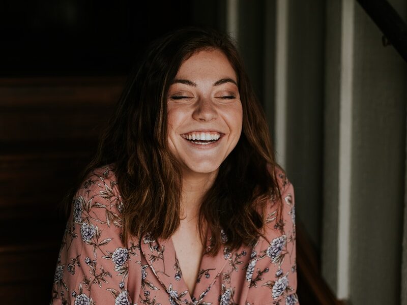 woman sitting on wooden stair smiling