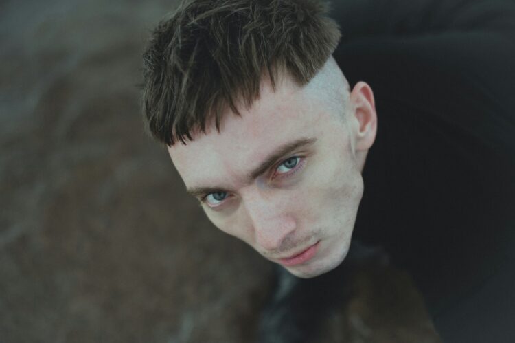 a close up of a person wearing a suit and tie