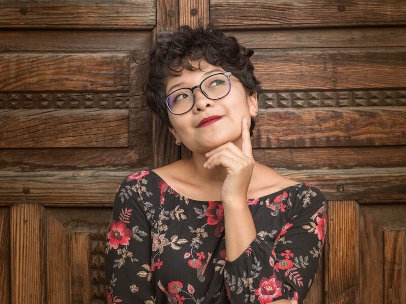 woman leaning against door while holding her cheek