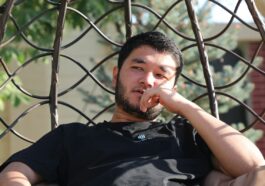 a man sitting in a hammock with his finger in his mouth