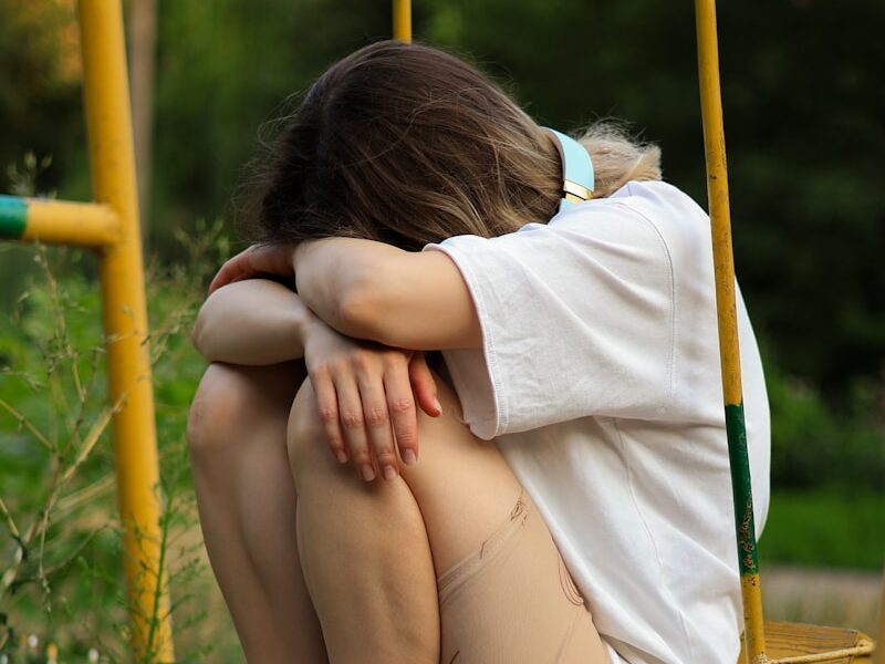 a woman sitting on a swing with her legs crossed