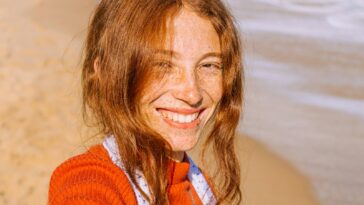 woman in red knit sweater smiling