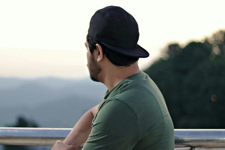 A man sitting on a bench with a hat on