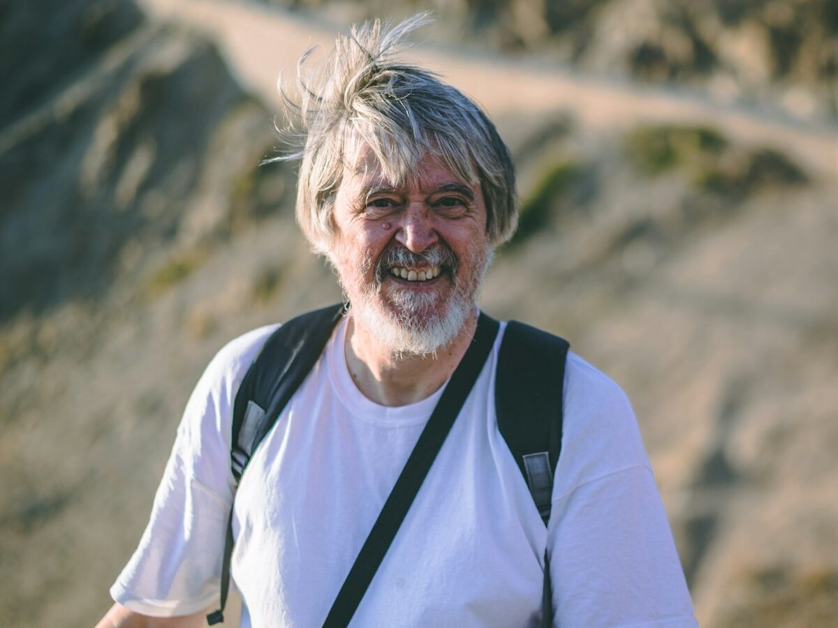 man wearing white crew-neck t-shirt with backpack