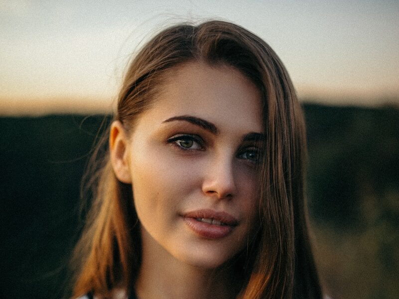 smiling woman wearing white and black pinstriped collared top