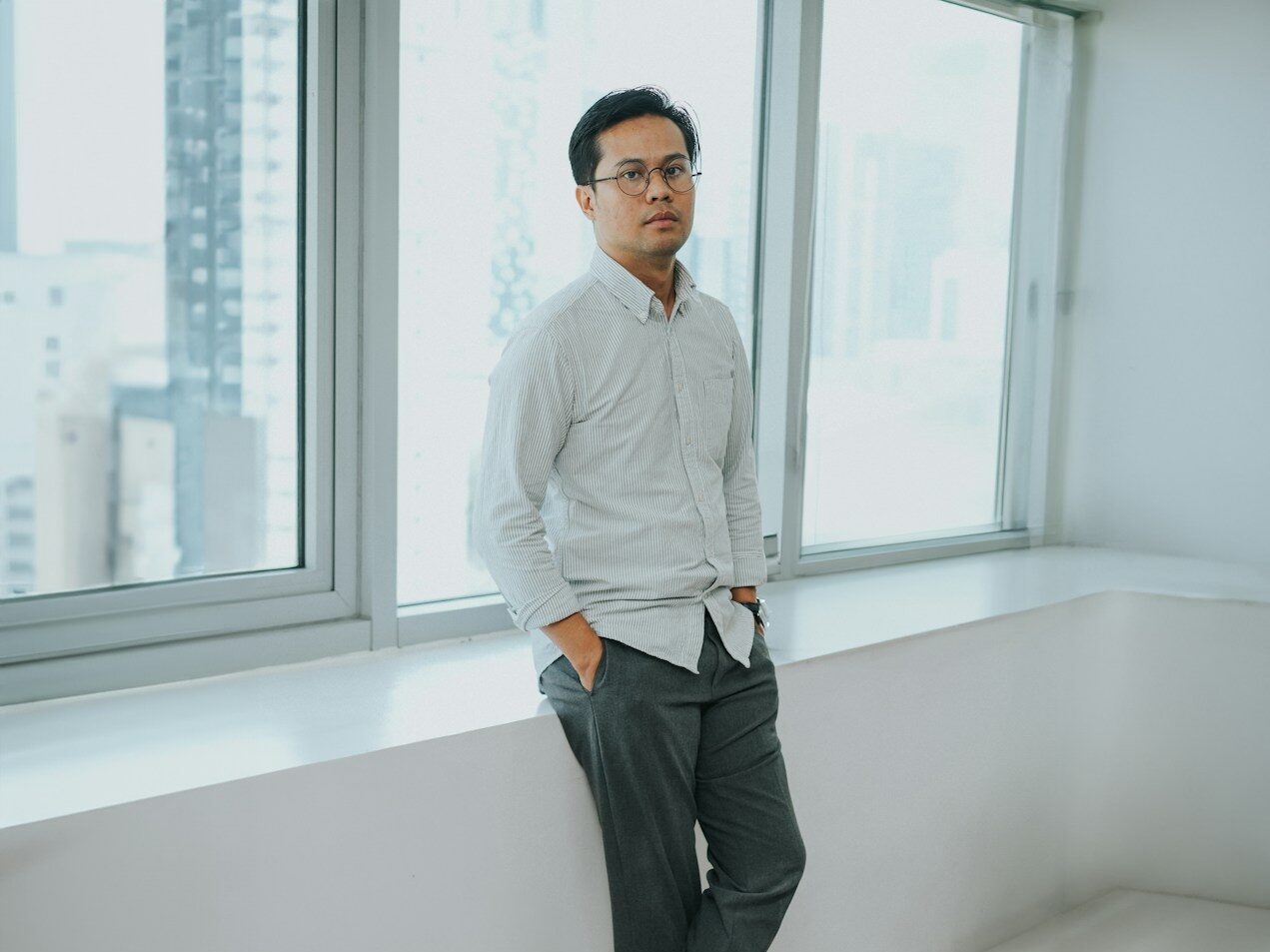 A man standing in front of a window in a room